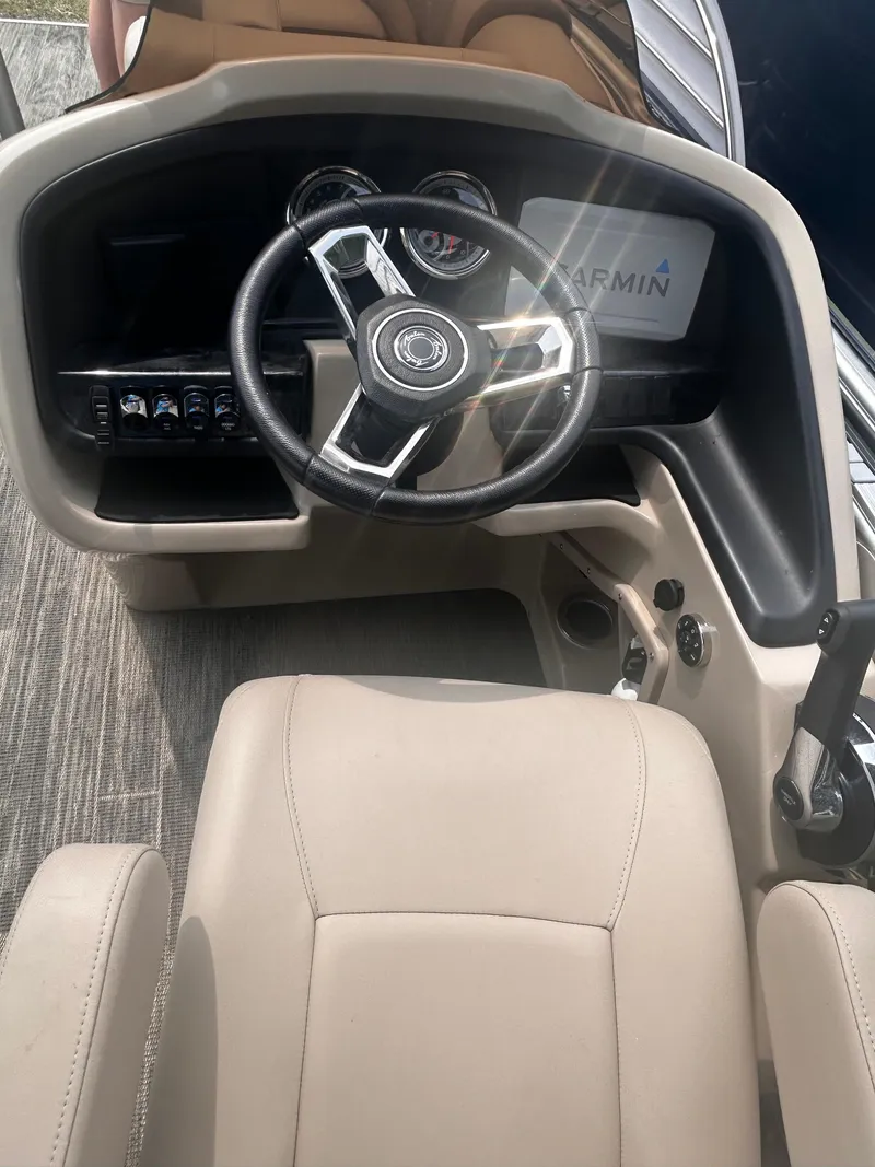 Slide: The Image of 2023 Avalon 2585 boat dashboard with steering wheel and Garmin display. - 12