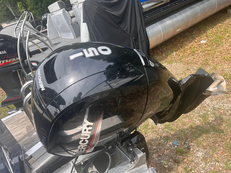 Slide: The Image of 2023 Avalon 2585 with Mercury 150 outboard motor, parked on grass. - 14