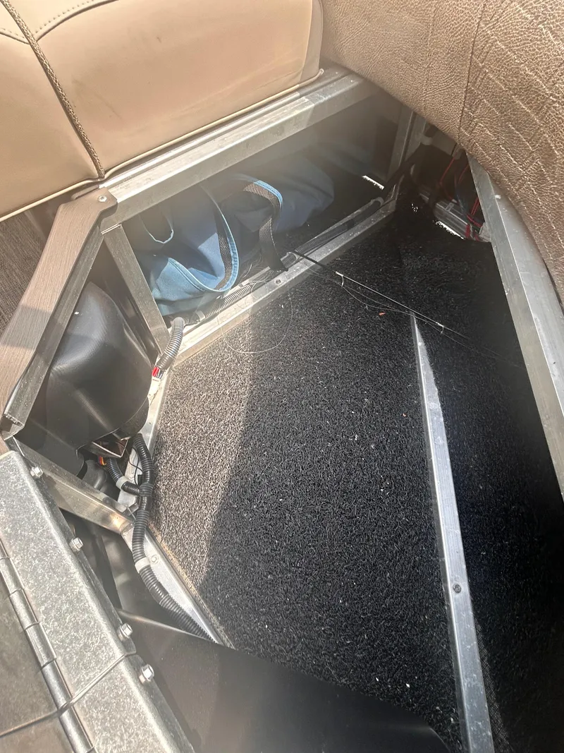 Slide: The Image of 2023 Avalon 2585 storage compartment with open seat, revealing interior space and bag. - 15