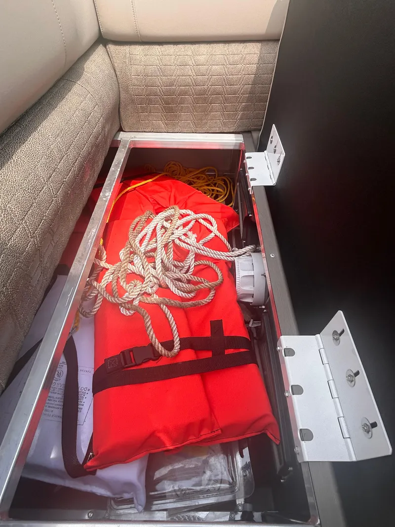 Slide: The Image of Storage compartment in 2023 Avalon 2585 boat with life jacket and rope. - 16