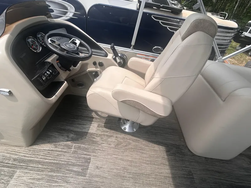 Slide: The Image of Captain's chair and helm of 2023 Avalon 2585 pontoon boat, featuring modern controls and dashboard. - 5