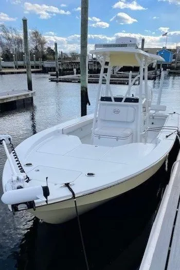 The Image of 2018 Hell's Bay Estero 24 boat docked in a marina under a partly cloudy sky. - 0