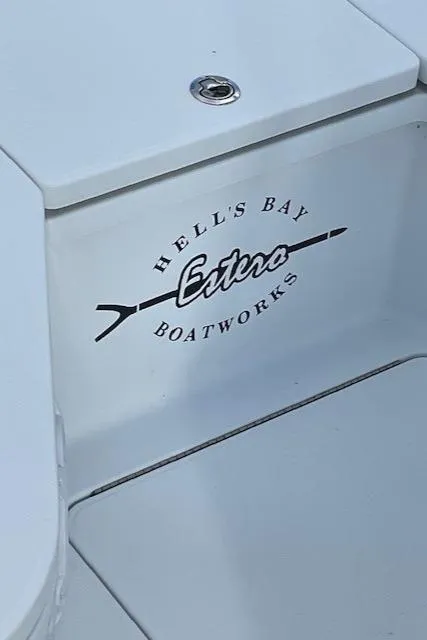 Slide: The Image of 2018 Hell's Bay Estero 24 boat logo on white surface. - 7