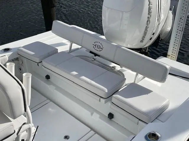 Slide: The Image of 2018 Hell's Bay Estero 24 boat interior with white seating and Mercury engine. - 8