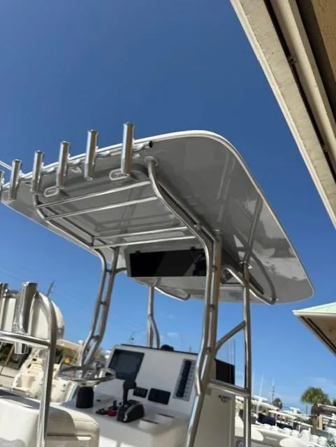 Slide: The Image of 2024 Bluewater 23 boat with T-top and rod holders under clear blue sky. - 3