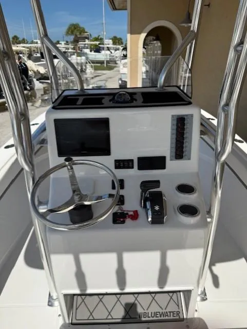 Slide: The Image of 2024 Bluewater 23 boat console with steering wheel, controls, and navigation screen. - 9