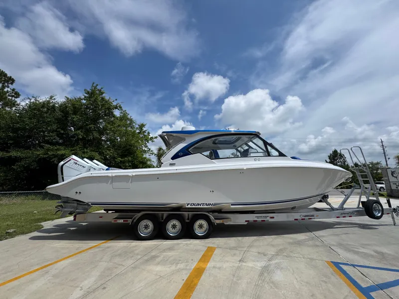 Slide: The Image of 2026 Fountain 39 DX boat on trailer under a partly cloudy sky. - 11