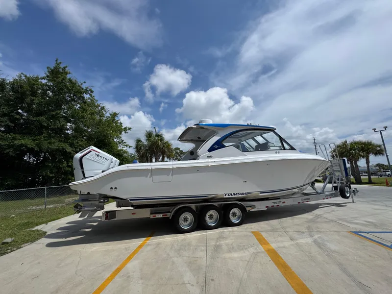 Slide: The Image of 2026 Fountain 39 DX boat on trailer, parked outdoors under a cloudy sky. - 12