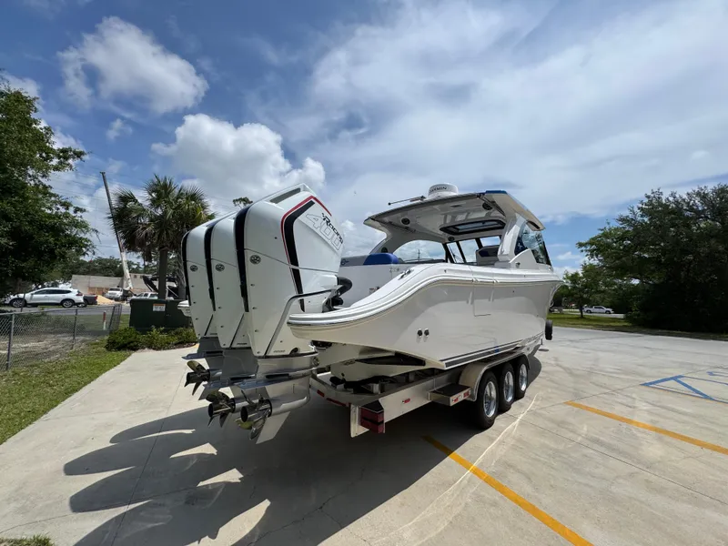Slide: The Image of 2026 Fountain 39 DX boat on trailer with triple outboard engines, parked outdoors. - 14