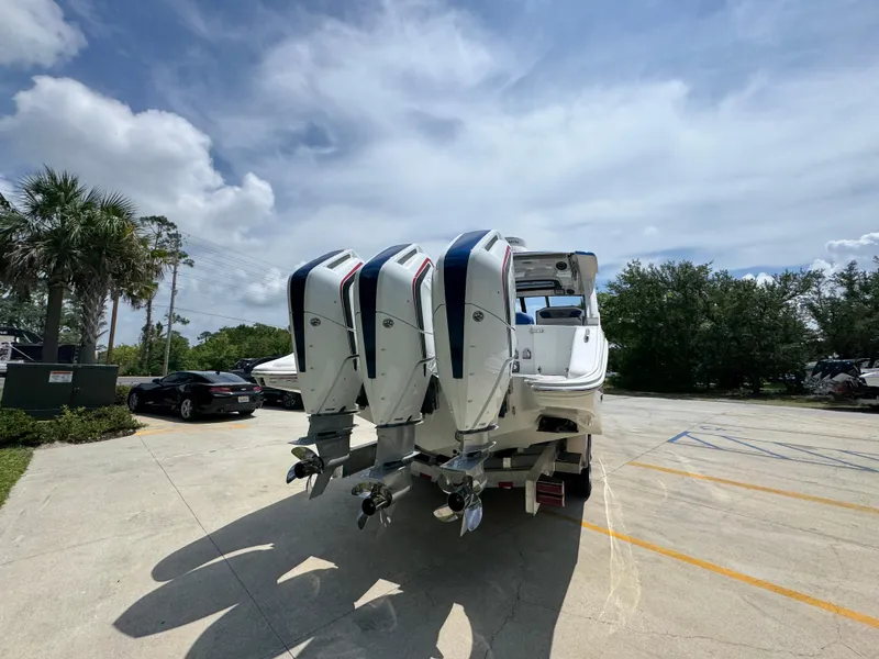 Slide: The Image of 2026 Fountain 39 DX boat with triple outboard engines in a sunny parking lot. - 15