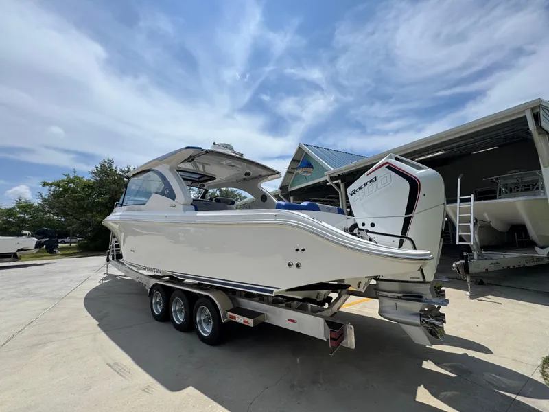 Slide: The Image of 2026 Fountain 39 DX boat on trailer, parked outdoors under a partly cloudy sky. - 18