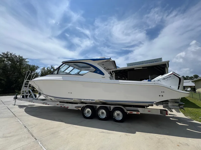 Slide: The Image of 2026 Fountain 39 DX boat on trailer under a partly cloudy sky. - 19