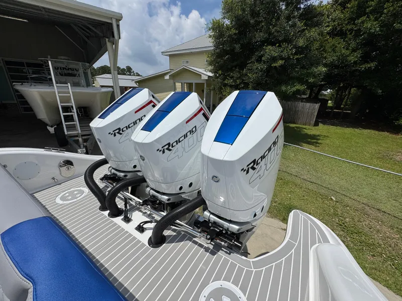 Slide: The Image of Triple outboard engines on a 2026 Fountain 39 DX boat, parked outdoors. - 47