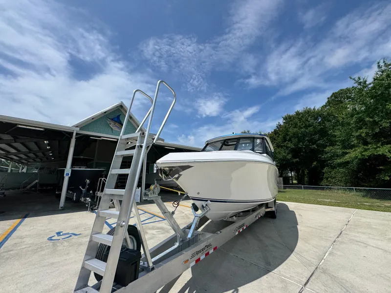 Slide: The Image of 2026 Fountain 39 DX boat on trailer under clear sky, parked near a building. - 5