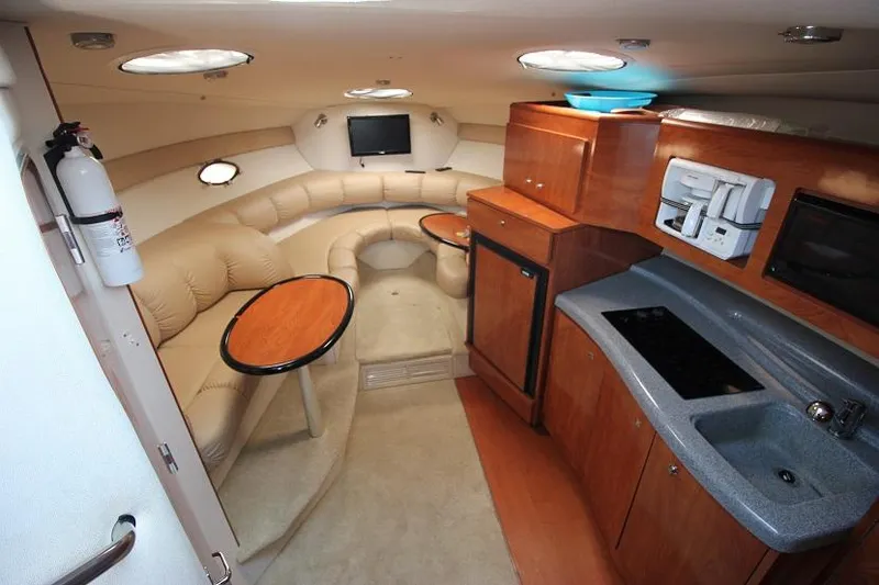 Slide: The Image of 2005 Larson Cabrio 310 cabin interior with kitchenette, seating area, and modern amenities. - 10