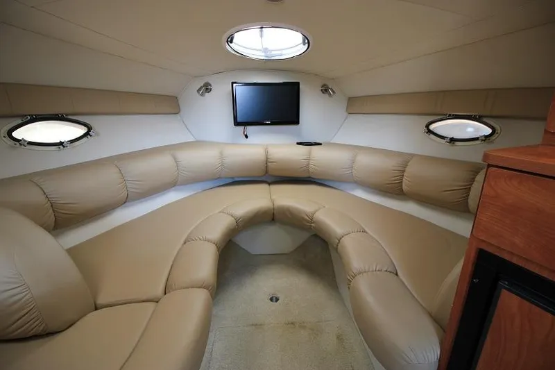 Slide: The Image of 2005 Larson Cabrio 310 interior with beige seating and wall-mounted TV. - 11