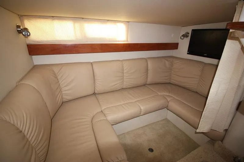 Slide: The Image of 2005 Larson Cabrio 310 interior with beige leather seating and wall-mounted TV. - 14