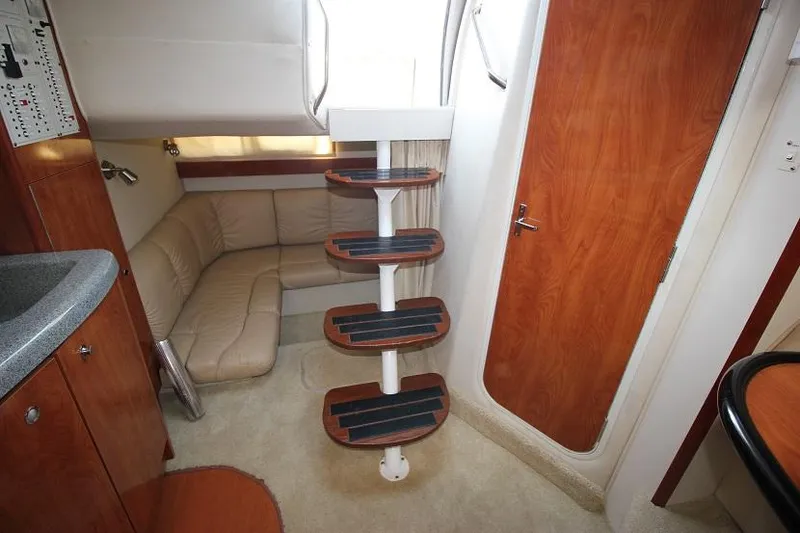 Slide: The Image of 2005 Larson Cabrio 310 interior with stairs, beige seating, and wooden accents. - 15