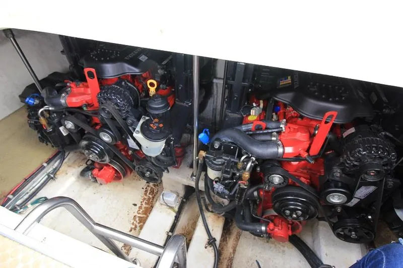 Slide: The Image of Engine compartment of a 2005 Larson Cabrio 310 boat, featuring dual red engines. - 19