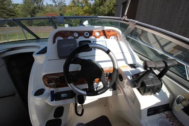 Slide: The Image of 2005 Larson Cabrio 310 boat dashboard with steering wheel and controls. - 7