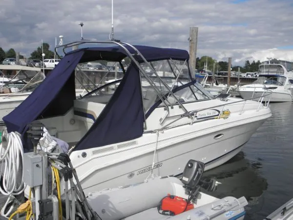 The Image of 1999 Rinker 280 Fiesta Vee boat docked at marina with blue canopy. - 1