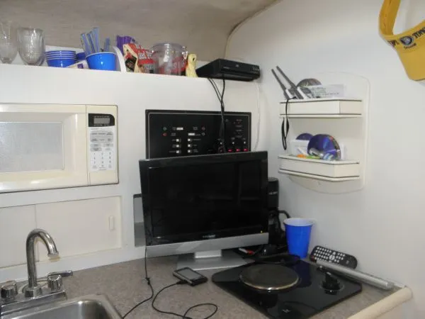 Slide: The Image of Interior of 1999 Rinker 280 Fiesta Vee boat with kitchen appliances and electronics. - 10