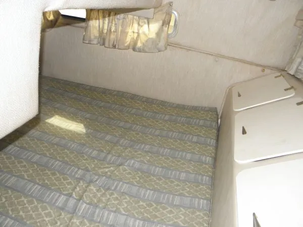 Slide: The Image of 1999 Rinker 280 Fiesta Vee cabin interior with bed and storage compartments. - 6