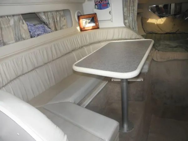 Slide: The Image of 1999 Rinker 280 Fiesta Vee cabin interior with dining table and seating area. - 7