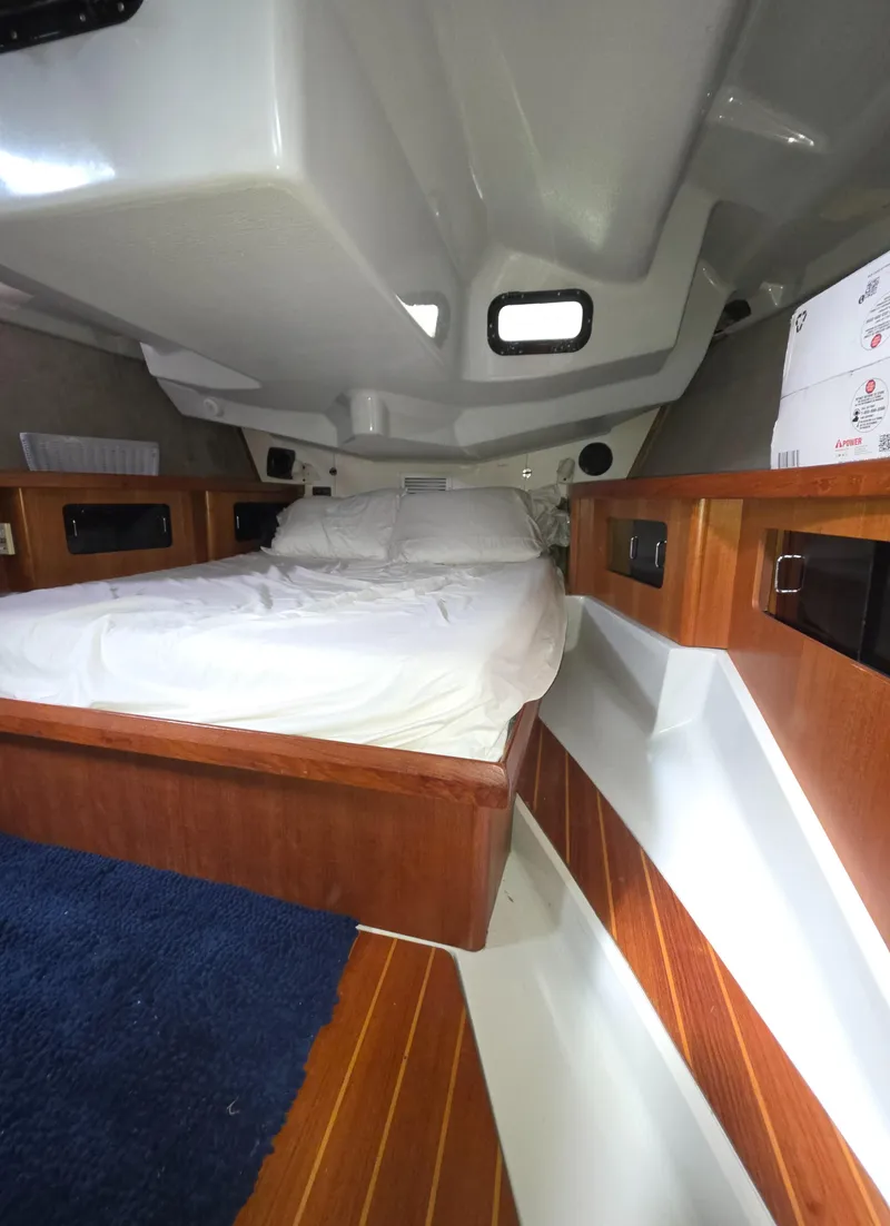 Slide: The Image of Interior cabin of 1989 Hunter Legend 37 sailboat with wooden accents and cozy bedding. - 15