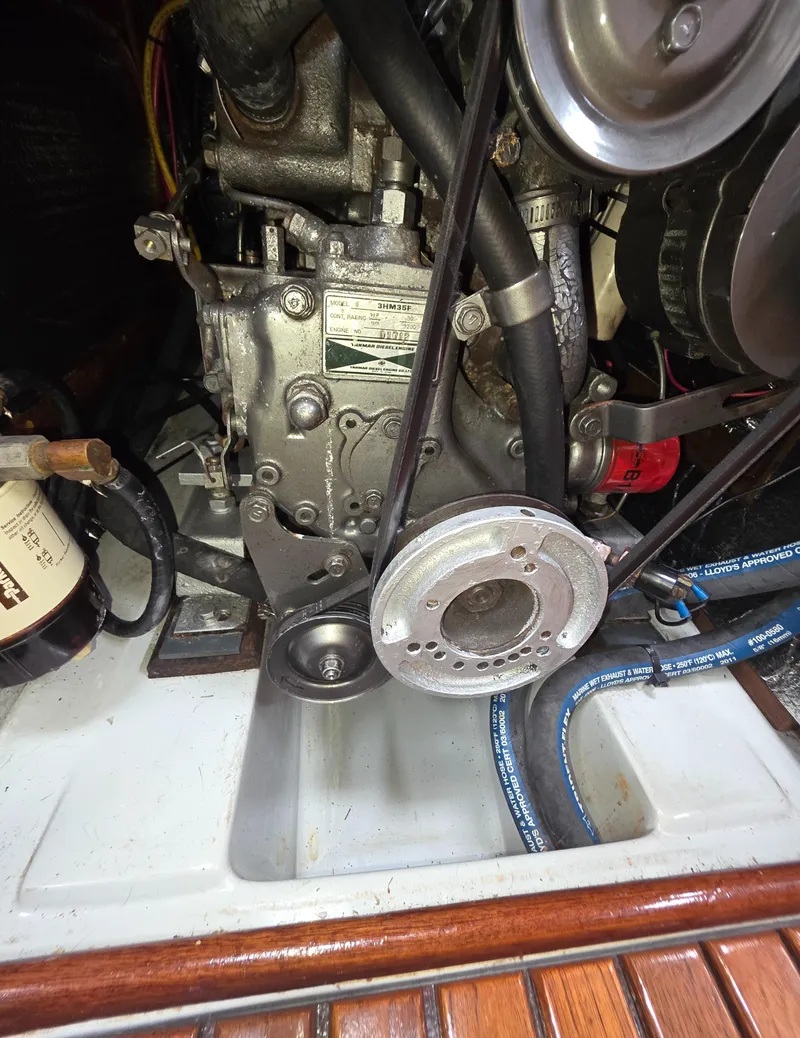 Slide: The Image of Engine compartment of a 1989 Hunter Legend 37 sailboat, showing mechanical components and belts. - 23