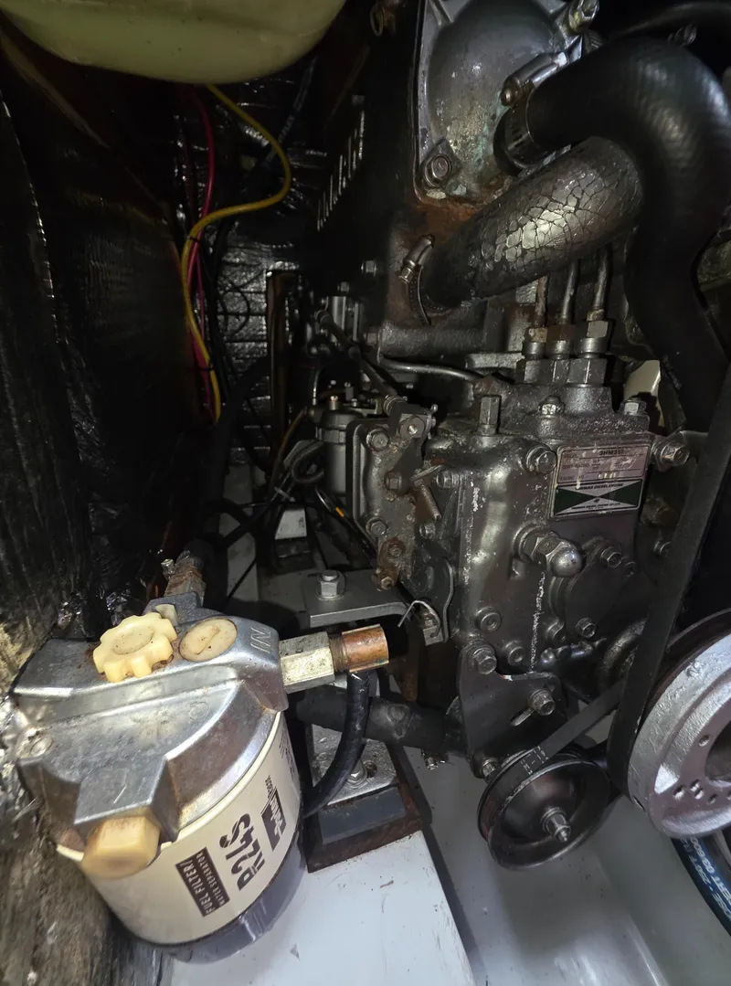 Slide: The Image of Engine compartment of a 1989 Hunter Legend 37 sailboat, showcasing mechanical components and wiring. - 24