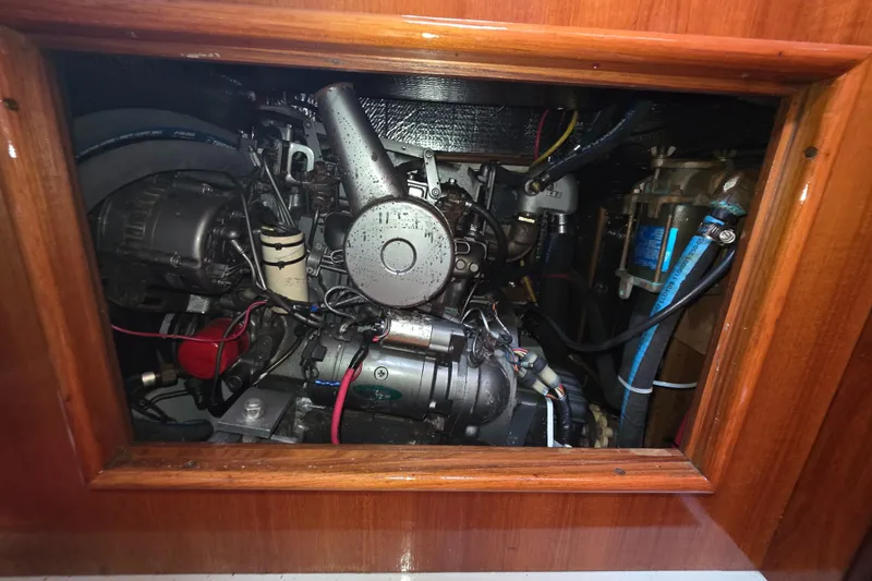Slide: The Image of Engine compartment of a 1989 Hunter Legend 37 sailboat, showcasing mechanical components and wiring. - 26