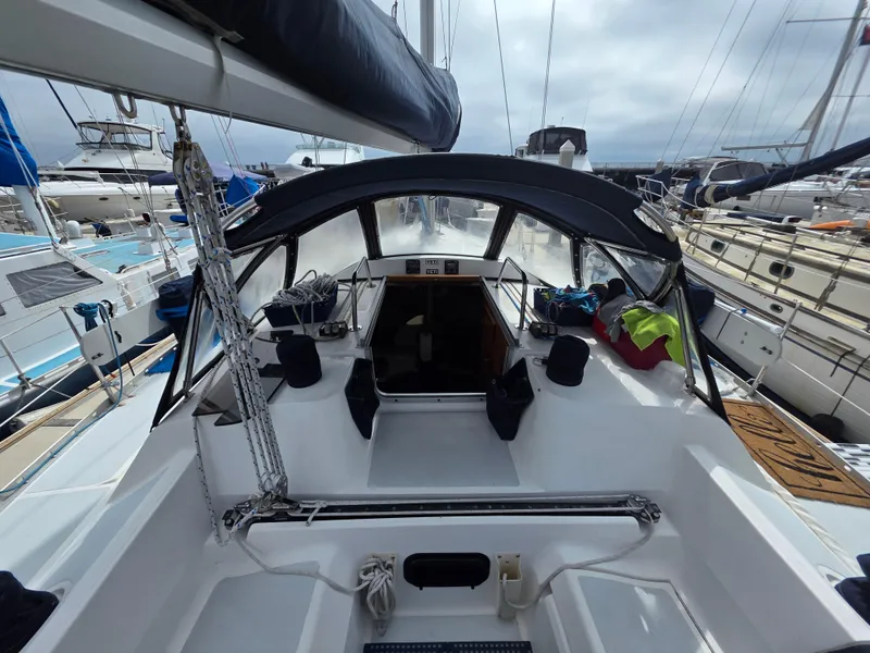 Slide: The Image of 1989 Hunter Legend 37 sailboat cockpit with canopy, docked among other boats. - 6