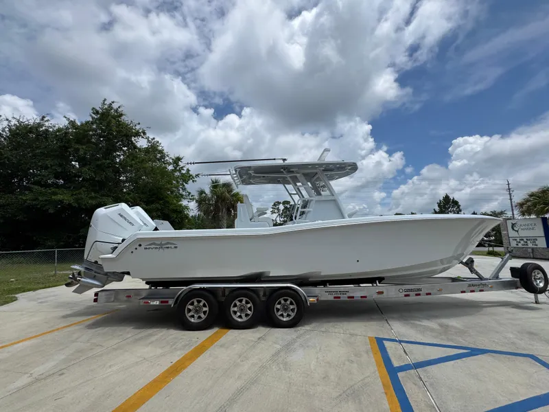 Slide: The Image of 2026 Invincible 33 Open Fisherman boat on a trailer under a cloudy sky. - 11