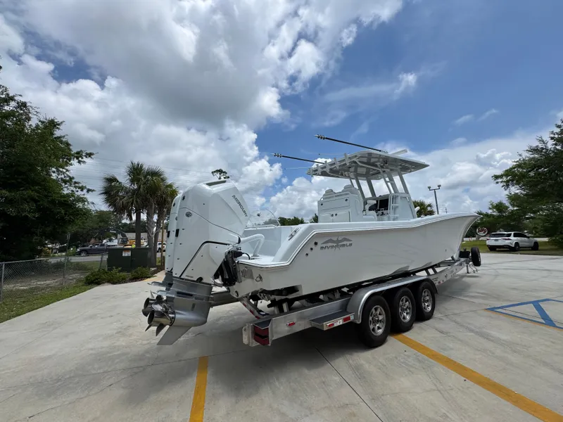 Slide: The Image of 2026 Invincible 33 Open Fisherman boat on trailer under cloudy sky. - 13