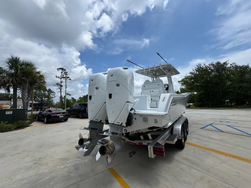 Slide: The Image of 2026 Invincible 33 Open Fisherman boat with dual engines on a trailer, parked outdoors. - 14