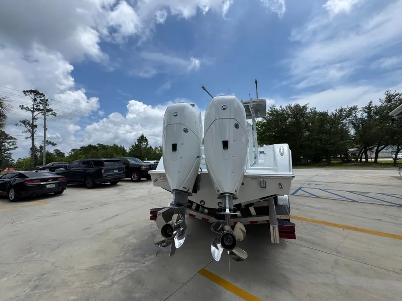 Slide: The Image of 2026 Invincible 33 Open Fisherman boat with dual outboard motors in a parking lot. - 15