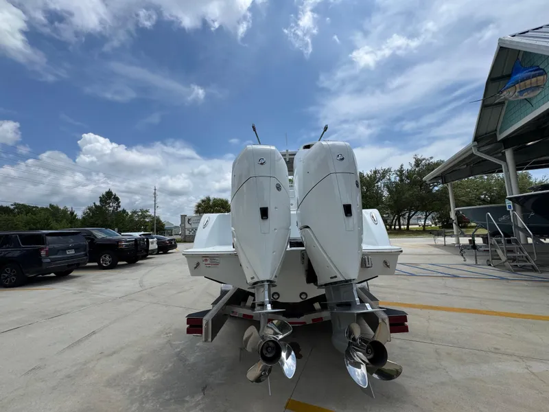 Slide: The Image of 2026 Invincible 33 Open Fisherman boat with dual outboard motors in a parking area. - 16