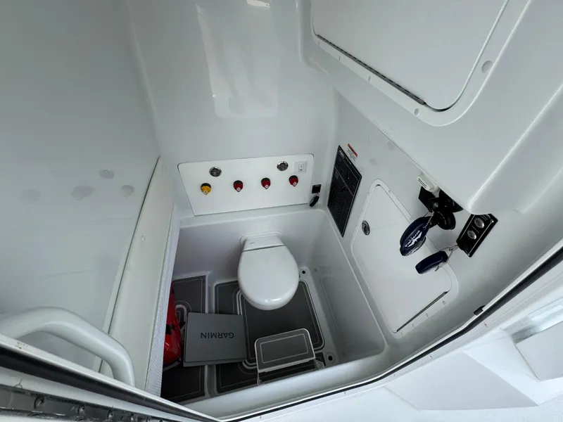 Slide: The Image of Interior of 2026 Invincible 33 Open Fisherman boat, featuring a compact marine toilet. - 29