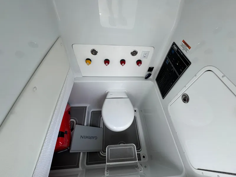 Slide: The Image of Interior of 2026 Invincible 33 Open Fisherman boat, featuring a compact marine toilet setup. - 31