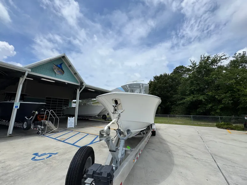 Slide: The Image of 2026 Invincible 33 Open Fisherman boat on trailer at marina under cloudy sky. - 6