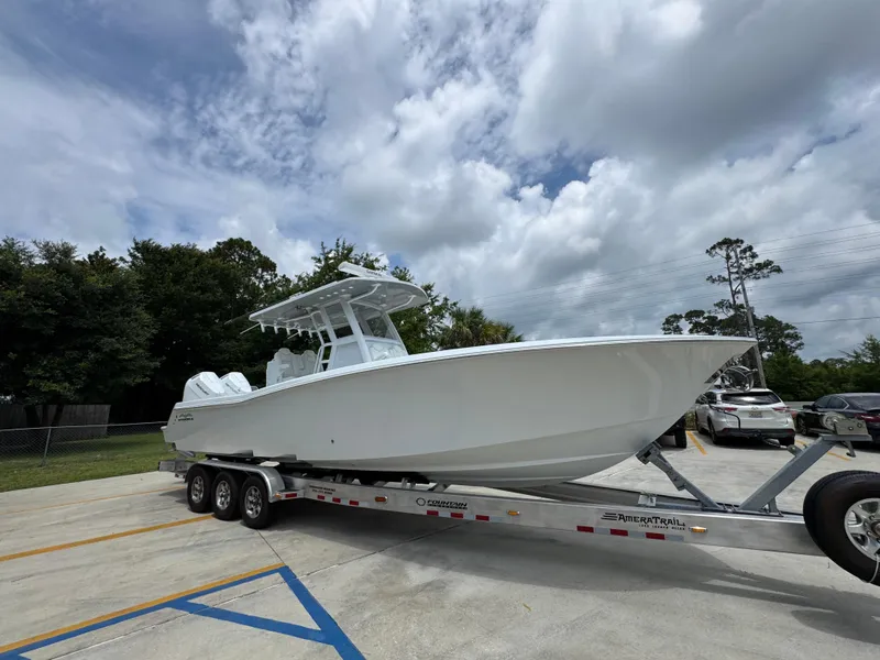 Slide: The Image of 2026 Invincible 33 Open Fisherman boat on trailer, parked outdoors under cloudy sky. - 9