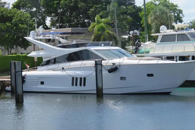 The Image of 2015 Mazarin 72 Sport Fly yacht docked in a marina, surrounded by lush greenery. - 0