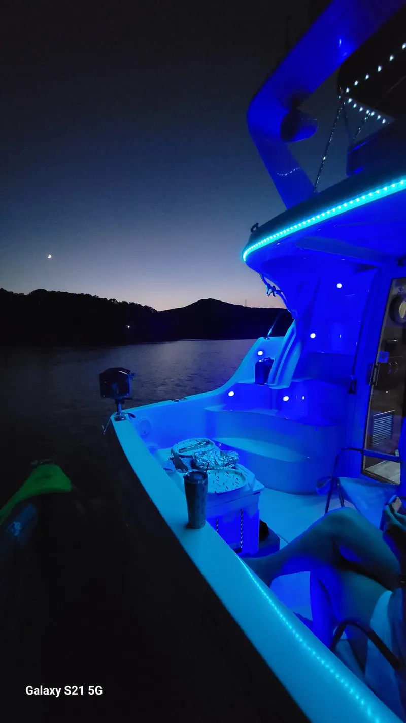 Slide: The Image of 2004 Carver 360 Sport Sedan with blue LED lights on a serene lake at dusk. - 17