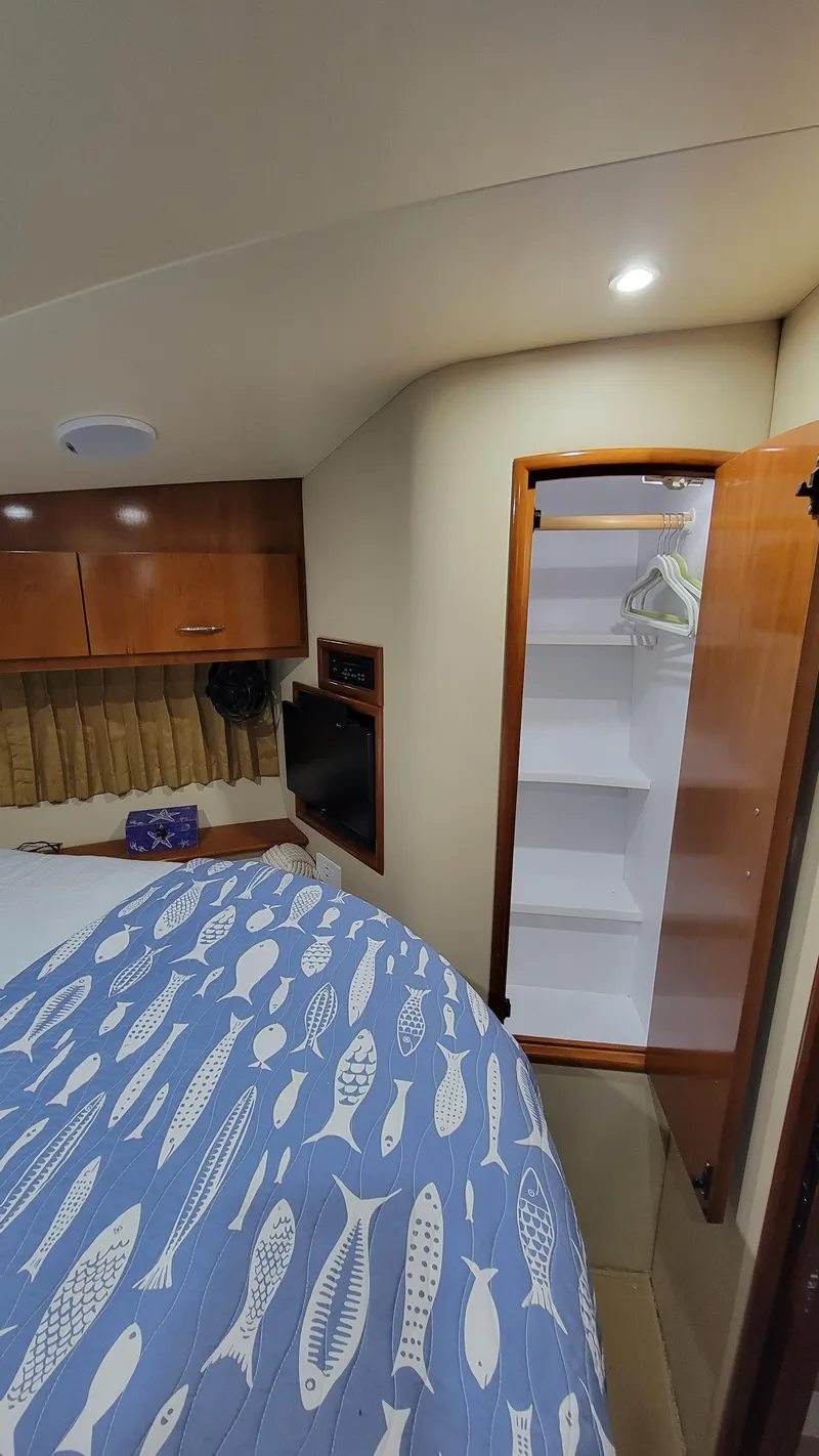 Slide: The Image of Interior of 2004 Carver 360 Sport Sedan with bed, closet, and wooden cabinetry. - 31