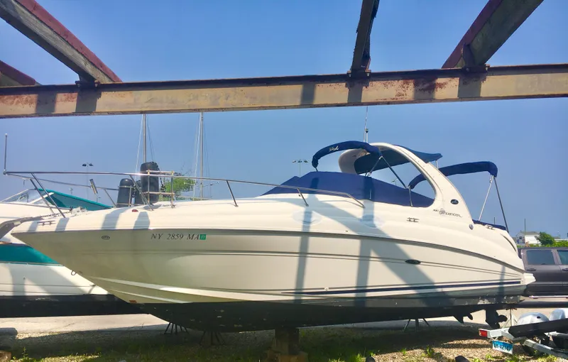 The Image of 2004 Sea Ray 280 Sundancer boat on display under a metal frame. - 0