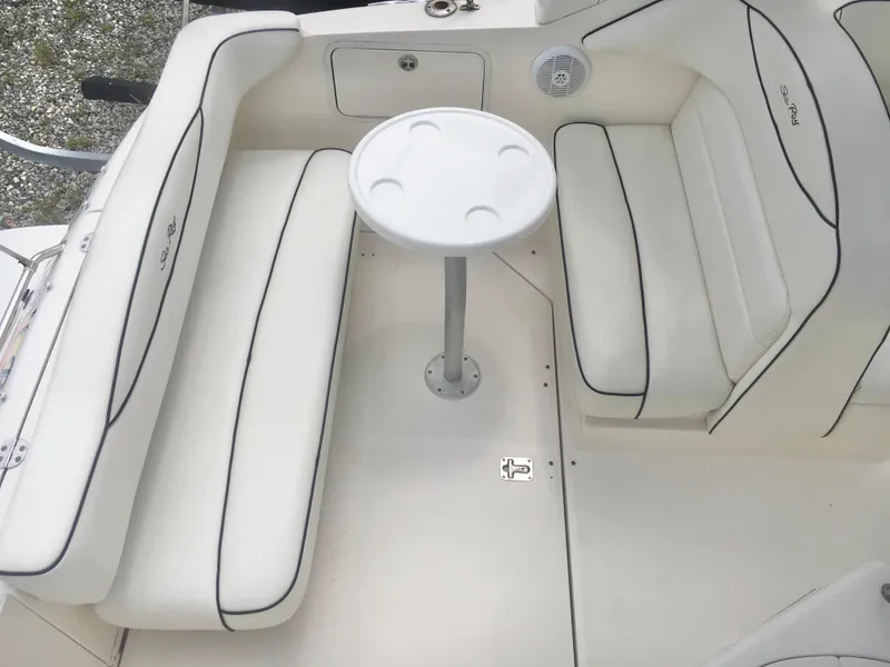 Slide: The Image of 2004 Sea Ray 280 Sundancer interior with white seating and a small round table. - 13