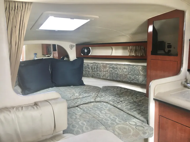 Slide: The Image of 2004 Sea Ray 280 Sundancer cabin interior with cozy seating and elegant wood finishes. - 15