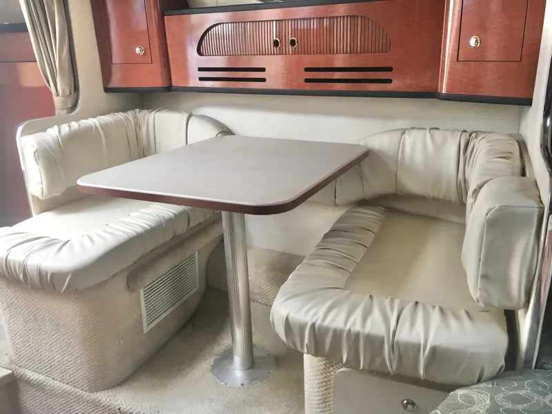 Slide: The Image of Interior of 2004 Sea Ray 280 Sundancer with cozy dining area and cushioned seating. - 18