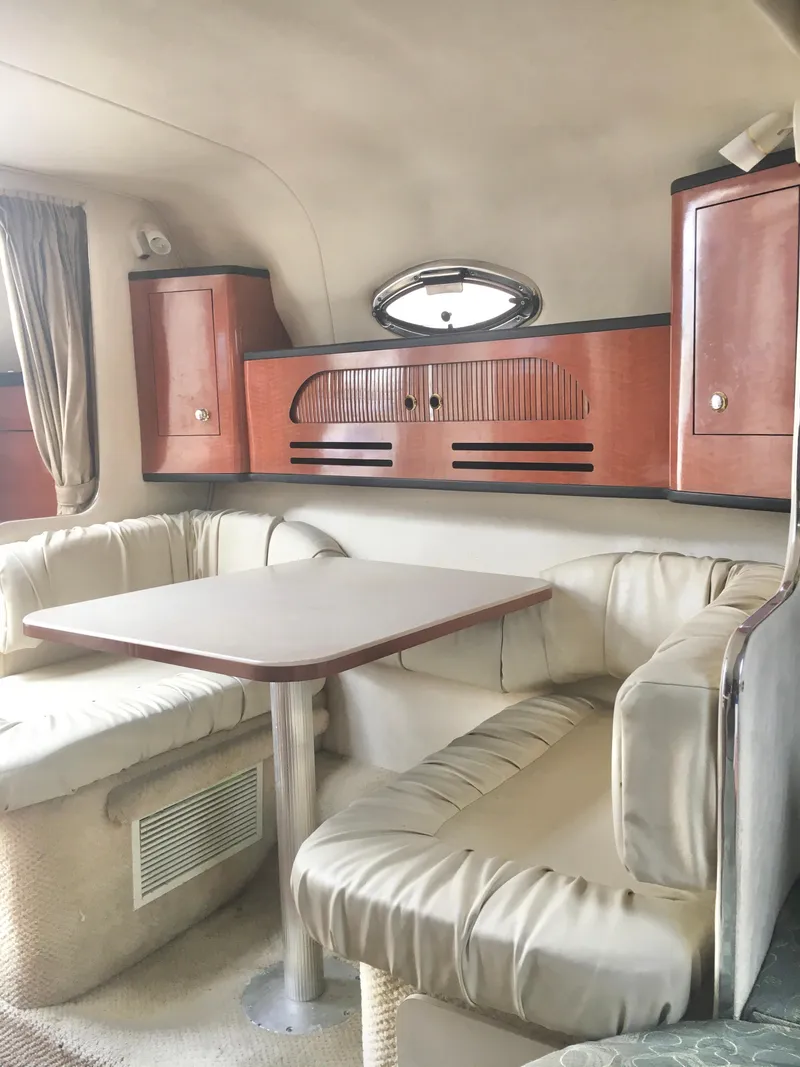 Slide: The Image of Interior of 2004 Sea Ray 280 Sundancer with cozy seating and wooden cabinetry. - 19